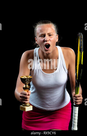 Schöne Mädchen Tennis Spieler mit einem Schläger auf dunklem Hintergrund, mit Licht feiern einwandfreien Sieg Stockfoto