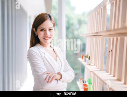 Lächelnden jungen asiatischen Geschäftsfrau mit verschränkten Armen. Stockfoto