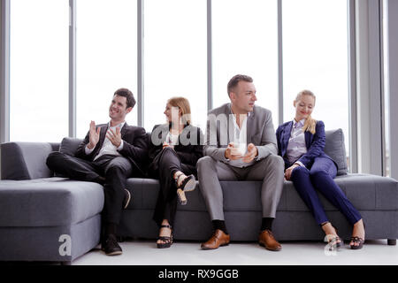 Portrait Geschäft Leute im Büro sitzen auf einem Sofa zu lächeln und zu sprechen. Stockfoto