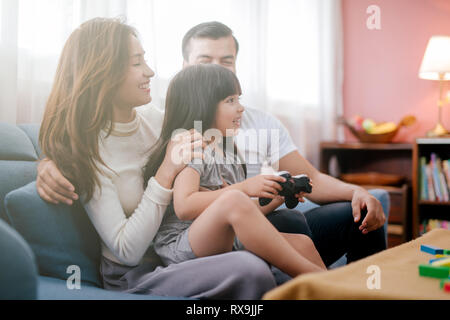 Kleines Mädchen und Eltern Familie spielen video Spiel zu Hause Stockfoto