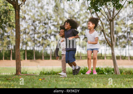 Kinder spielen im Freien mit Freunden. kleine Kinder spielen im Naturpark. Stockfoto