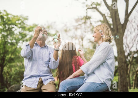 À¹‡Happy Family schlag Seifenblasen in Park. Stockfoto