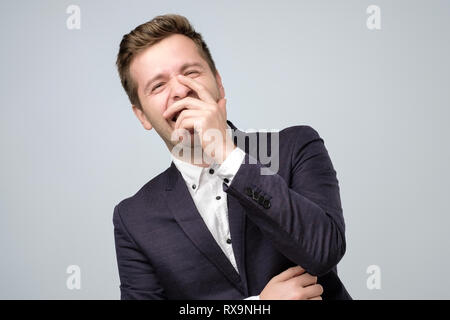 Portrait Gesicht der jungen europäischen Geschäftsmann auf grauem Hintergrund lachen. Positive facial Emotion Stockfoto