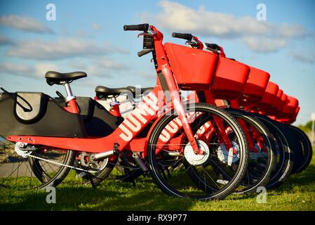 Uber Springen reiten-sharing (Fahrrad) Rot, elektrische Fahrräder (e-bikes) bis auf Gras auf Harbour Island, San Diego, USA gefüttert Stockfoto