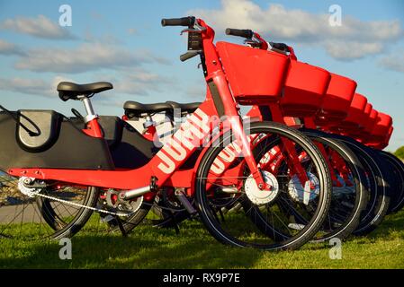 Uber Springen reiten-sharing (Fahrrad) Rot, elektrische Fahrräder (e-bikes) bis auf Gras auf Harbour Island, San Diego, USA gefüttert Stockfoto