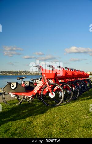 Uber Springen reiten-sharing (Fahrrad) Rot, elektrische Fahrräder (e-bikes) bis auf Gras auf Harbour Island, San Diego, USA gefüttert Stockfoto