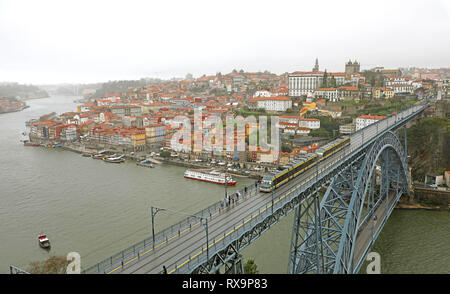 Blick auf die historische Stadt Porto, Portugal mit der Dom Luiz Brücke. Eine U-Bahn kann auf der Brücke gesehen werden. Stockfoto