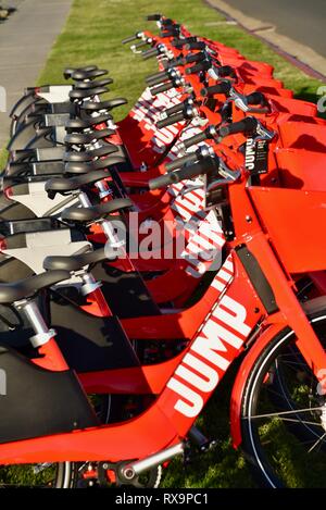 Uber Springen reiten-sharing (Fahrrad) Rot, elektrische Fahrräder (e-bikes) bis auf Gras auf Harbour Island, San Diego, USA gefüttert Stockfoto