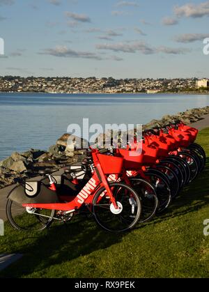 Uber Springen reiten-sharing (Fahrrad) Rot, elektrische Fahrräder (e-bikes) bis auf Gras auf Harbour Island, San Diego, USA gefüttert Stockfoto