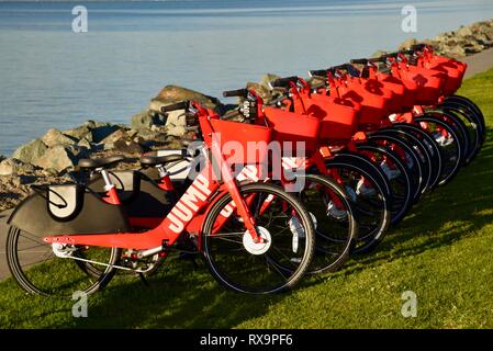 Uber Springen reiten-sharing (Fahrrad) Rot, elektrische Fahrräder (e-bikes) bis auf Gras auf Harbour Island, San Diego, USA gefüttert Stockfoto