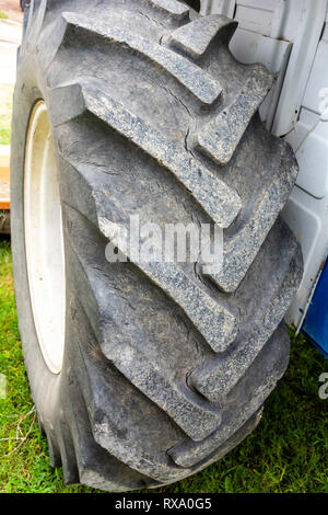 Abgenutzten alten Traktor Hinterreifen bereit zu ersetzen - Austauschen der Traktor beschädigt Reifen - Nicht sicher für die Verwendung von Traktor Hinterreifen Stockfoto