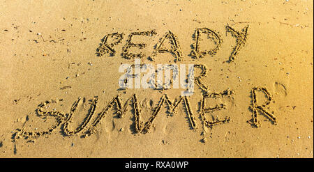 Hand in Sand bereit für den Sommer Worte Top View - Schreiben im Sand am Strand im warmen Sonnenlicht - Konzept geschrieben von Vorbereitungen für den Sommerurlaub Stockfoto