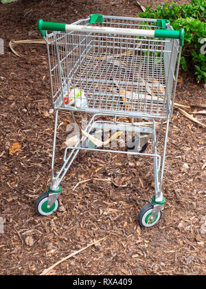 Supermarkt Einkaufswagen verlassen in einem Garten Stockfoto