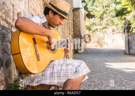Ein junger Mann in Spielen Flamenco Gitarre seinen Anfang 20 in einer Gasse; Granada, Spanien. Stockfoto
