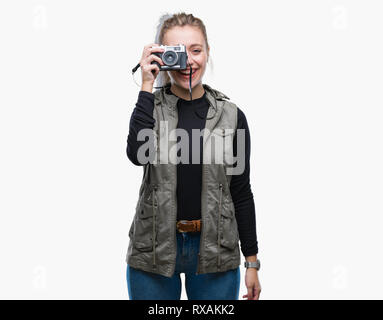 Junge blonde Frau, Aufnahme von Bildern mit Vintage Kamera über isolierte Hintergrund mit einem glücklichen Gesicht stehen und lächelnd mit einem selbstbewussten Lächeln angezeigt Stockfoto