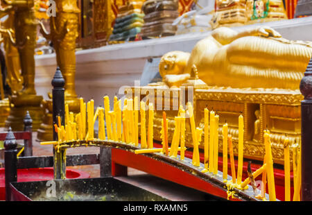 Kerzen in einem Tempel in der Nähe des Liegenden Buddha Tempel, auch Wat Pho genannt. In Bangkok, Thailand. Stockfoto