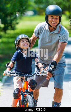 Großvater und Enkel genießen, Radfahren und Skaten Stockfoto