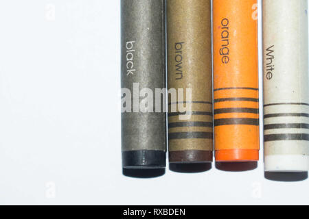 Schwarz, Braun, Orange und Weiß Buntstifte mit einer Farbe Namen geschrieben auf einen Zeichenstift Stockfoto