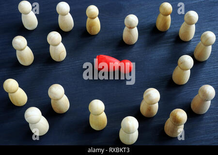 Mobbing am Arbeitsplatz zu belästigen und Einsamkeit Konzept. Holzfiguren auf einem Schreibtisch. Stockfoto