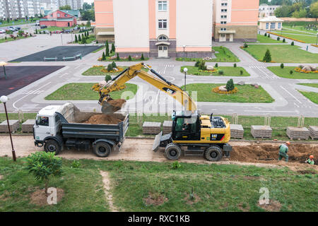 GRODNO, Weißrussland - September 2018: Bagger gräbt eine Grube und lädt die Sand auf einem Dump Truck Stockfoto