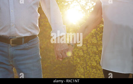 Liebe Konzept. Ältere Paare, Hände auf den Sonnenuntergang. CLOSE-UP Stockfoto