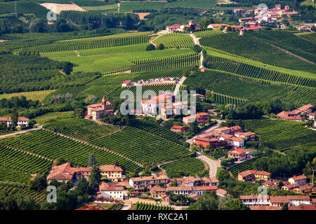 Kleine Stadt inmitten grüner Weinberge auf den Hügeln des Piemont, Norditalien. Stockfoto