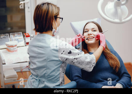 Schöne Mädchen sitzen in der Zahnarztpraxis Stockfoto