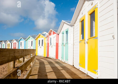 Bunten Badekabinen mit bewaldeten Promenade mit Blick auf den Strand an der Bude Cornwall Stockfoto