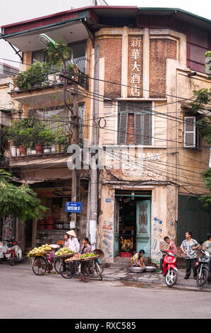 Lokalen Vietnamesischen am Straßenrand mit Fahrrädern tragen Früchte warten auf Kunden, Hanoi, Vietnam