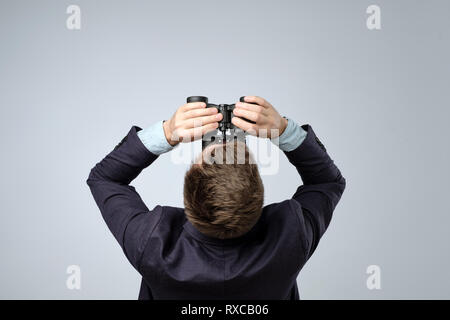 Mann in Anzug Blick durch ein Fernglas. Ansicht von oben. Suchen nach Informationen Stockfoto