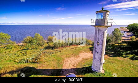 Den Leuchtturm auf der Klippe der See. Es gibt eine gelbe Bulldozer, um vor der Kirche in Peipsi Stockfoto