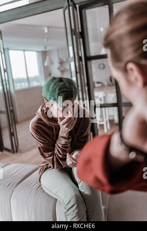 Grün - behaarte Frau weinend und fühlen sich hilflos in verrückten Mann Stockfoto