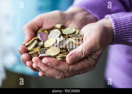 Rentner woman holding in den Händen Euro Münzen. Thema der niedrigen Renten. Stockfoto