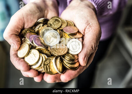 Rentner woman holding in den Händen Euro Münzen. Thema der niedrigen Renten. Stockfoto