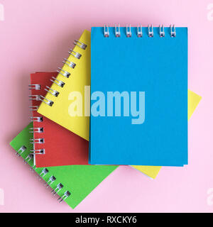 In der Nähe der bunten Notebooks mit Pastell rosa Hintergrund minimal kreatives Konzept. Platz für Kopieren. Stockfoto
