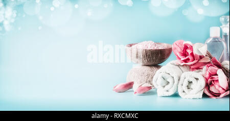 Schöne rosa weiß Spa mit Bettwäsche, Blumen, Kerzen, Meersalz und Körperpflege Kosmetik Bei hellblauen Hintergrund mit Bokeh, Banner. Schönheit c Stockfoto