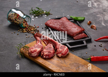 Satz von Roh ungekocht Black Angus Rind tomahawk Steaks auf Knochen und Kalbsfilet mit Chili und Pfeffer. Im rustikalen Stil. Nahaufnahme Stockfoto