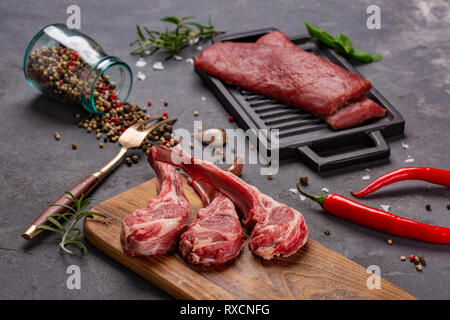 Satz von Roh ungekocht Black Angus Rind tomahawk Steaks auf Knochen und Kalbsfilet mit Chili und Pfeffer. Im rustikalen Stil. Nahaufnahme Stockfoto