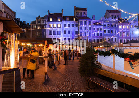 Polen, Warschau, Menschen genießen Sie Ihre Getränke am Marktplatz in der Altstadt im winter nacht während der Weihnachtszeit. Stockfoto