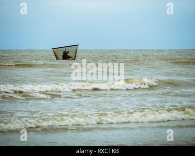 Fischer scheint in seinem eigenen Netz im Wasser gefangen zu werden. Stockfoto