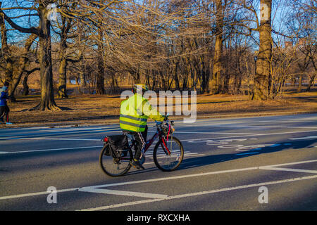 Mann, der grüne Weste Reiten Fahrrad auf dem Prospect Park in Brooklyn, New York, Februar Stockfoto