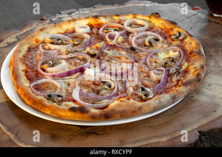 Pizza mit saurer Sahne, Schinken, Pilze, roten Zwiebeln, rote geröstete Paprika, Gelb, Käse, Olivenöl und Oregano. Stockfoto