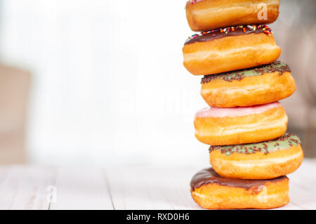 Bunt glasierter Krapfen auf Holz Tisch. Gebäck Konzept Stockfoto