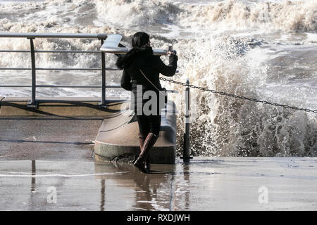 Blackpool, Lancashire, UK. Stürmisches Wetter. 9. März 2019. Starke Winde bei Flut erstellen Der perfekte Sturm der Küste von Blackpool, Lancashire zu schlagen. Touristen und Einheimische Herde an der Promenade einige wave Ausweichen an der Küste entlang zu tun. Credit: cernan Elias/Alamy leben Nachrichten Stockfoto