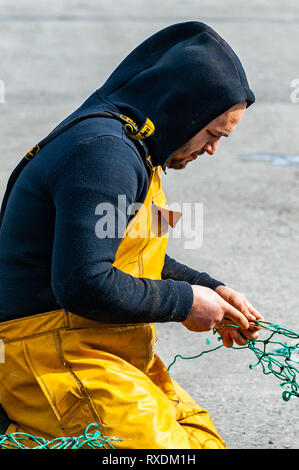 Union Hall, West Cork, Irland. 9. März, 2019. Fischer flicken, gebrochene Netze auf der fischtrawler "Ocean Pioneer", während in der Union Halle Angeln Hafen. Credit: Andy Gibson/Alamy Leben Nachrichten. Stockfoto