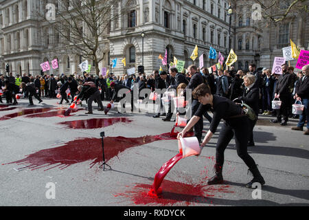 London, Großbritannien. 9 Mär, 2019. Klima Aktivisten vor dem Aussterben Rebellion gießen künstliches Blut auf dem Boden außerhalb der Downing Street als Teil einer Akt zivilen Ungehorsams namens "das Blut unserer Kinder" auf die Regierung auf, unverzüglich Schritte einzuleiten, um dem aktuellen Klima und ökologische Not zu bekämpfen. Credit: Mark Kerrison/Alamy leben Nachrichten Stockfoto