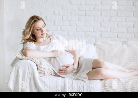 Bis zu schließen. junge schwangere Frau auf der Couch liegend Stockfoto