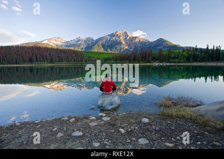 Mittleres Alter Mann Meditation am frühen Morgen im Pyramid Lake, Jasper National Park, Alberta, Kanada. Stockfoto