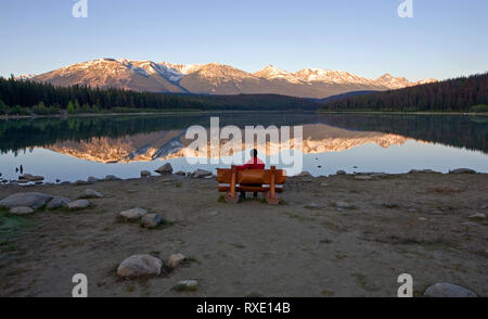 Mittleres Alter Mann auf der Bank, die Patricia Lake, Jasper National Park, Alberta, Kanada. Stockfoto