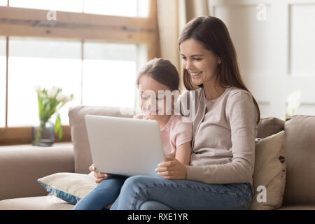 Glückliche Mutter und Kind Tochter Laptop Computer zu Hause. Stockfoto